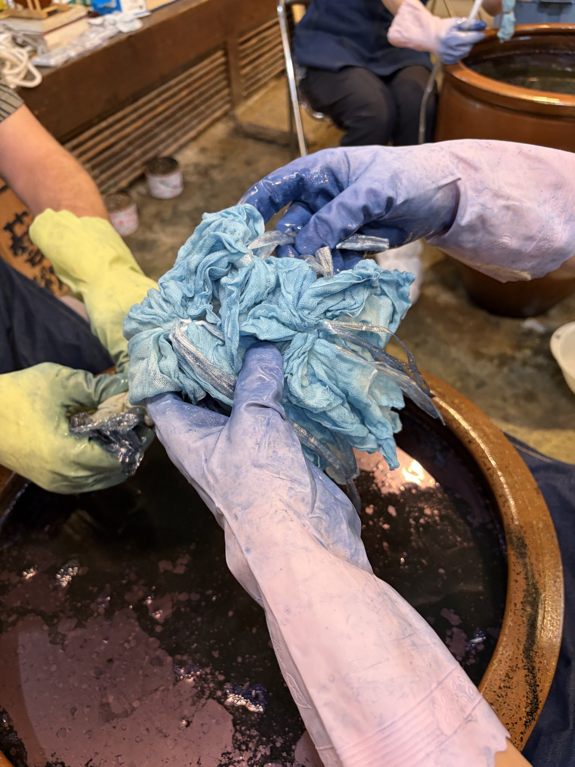 Close-up of hands wringing out indigo-dyed fabric