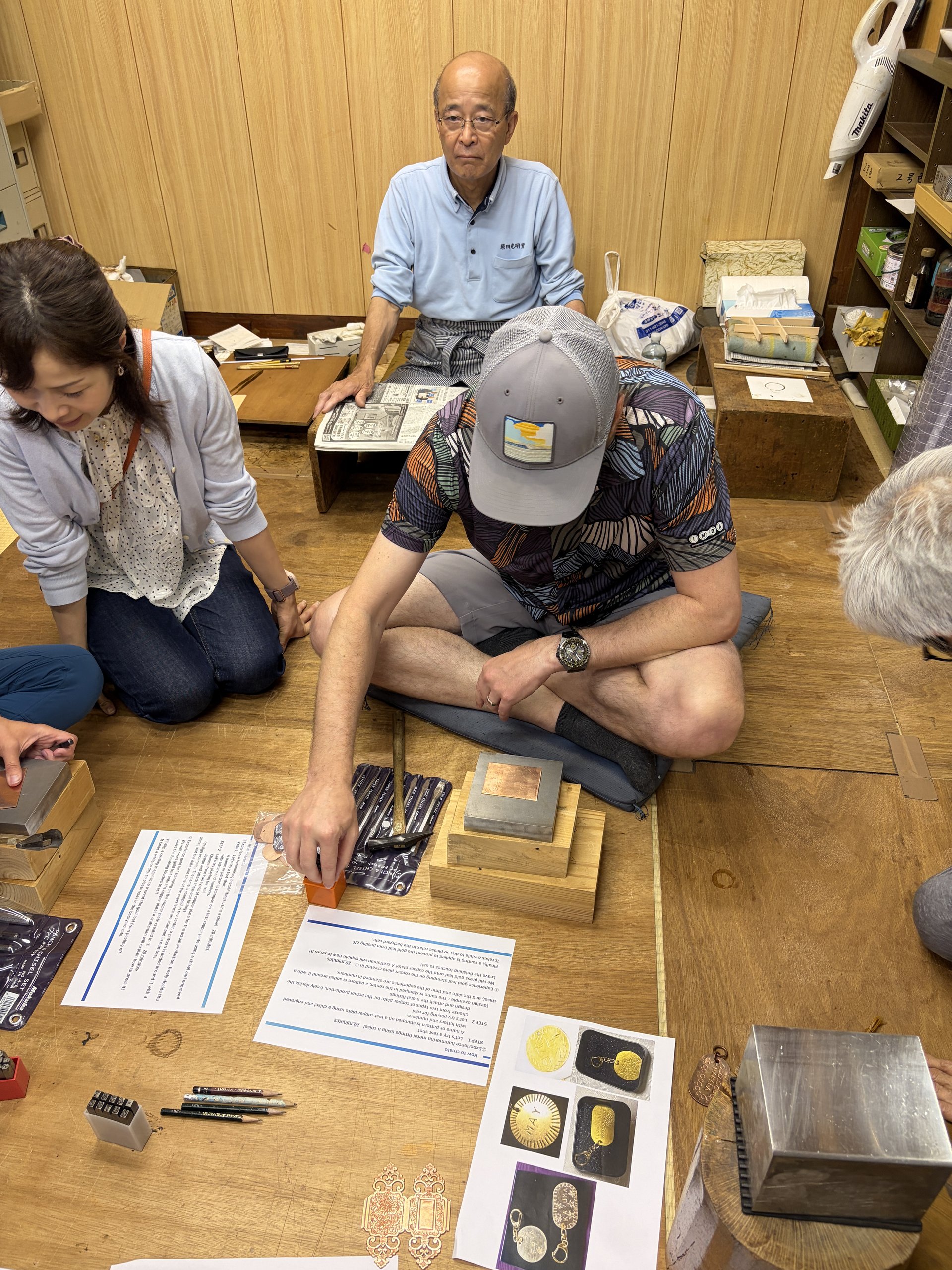 Gold leaf craftsman explaining the process to guests