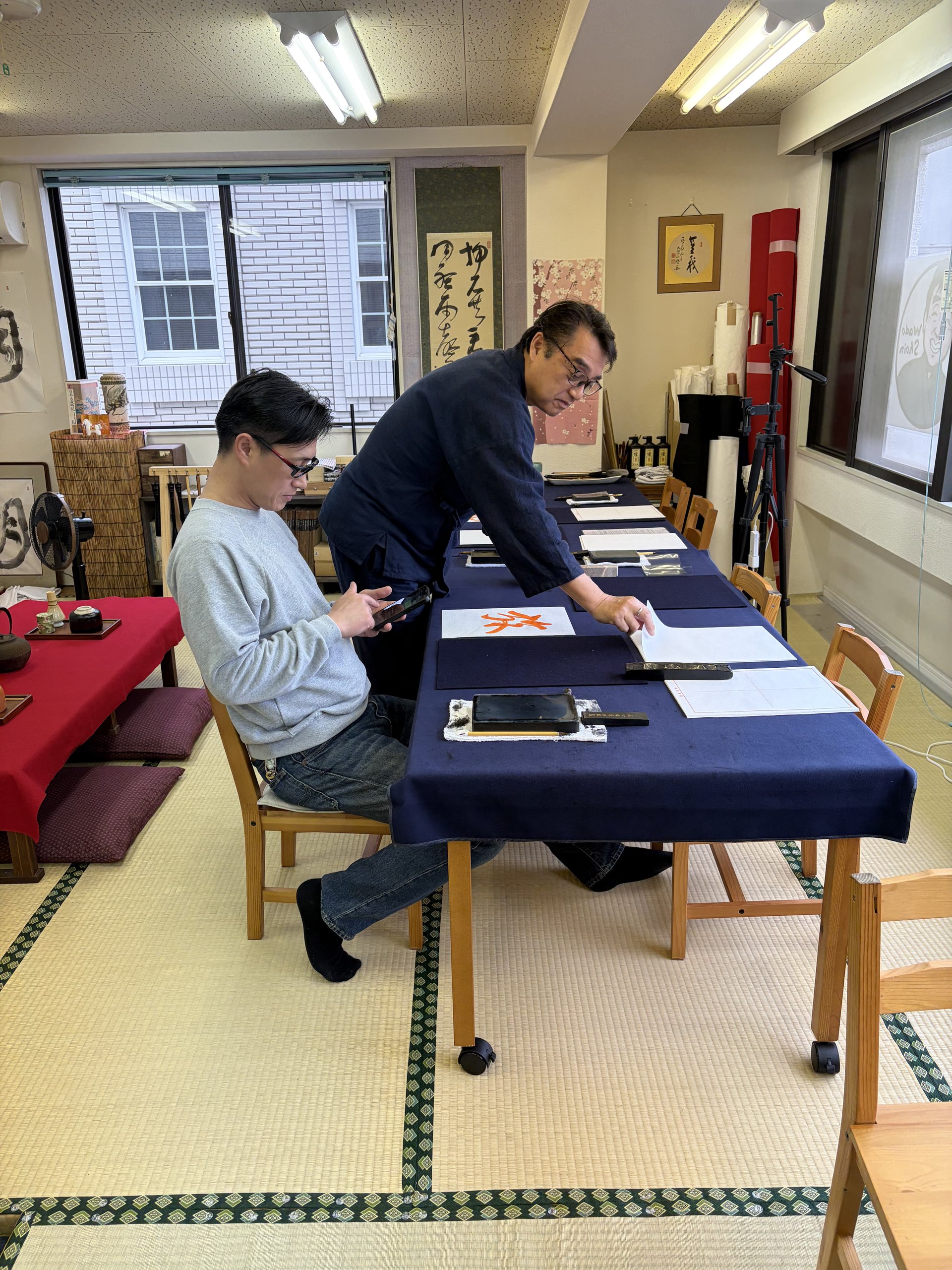 Calligraphy instructor guiding a guest